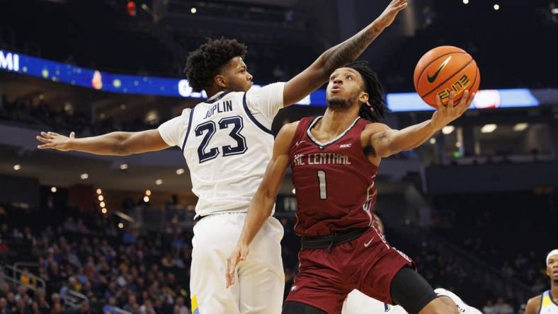 Dec 6, 2022; Milwaukee, Wisconsin, USA;  North Carolina Central Eagles guard Ja'darius Harris (1) shoots around Marquette Golden Eagles forward David Joplin (23) during the first half at Fiserv Forum. Mandatory Credit: Jeff Hanisch-USA TODAY Sports