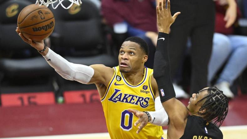 Dec 6, 2022; Cleveland, Ohio, USA; Los Angeles Lakers guard Russell Westbrook (0) drives against Cleveland Cavaliers forward Isaac Okoro (35) in the fourth quarter at Rocket Mortgage FieldHouse. Mandatory Credit: David Richard-USA TODAY Sports