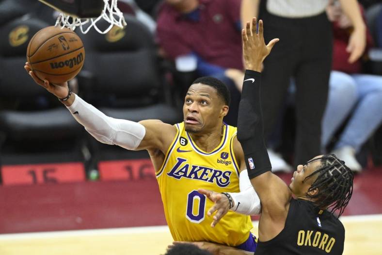 Dec 6, 2022; Cleveland, Ohio, USA; Los Angeles Lakers guard Russell Westbrook (0) drives against Cleveland Cavaliers forward Isaac Okoro (35) in the fourth quarter at Rocket Mortgage FieldHouse. Mandatory Credit: David Richard-USA TODAY Sports