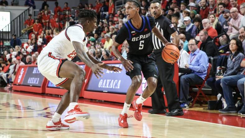 Dec 7, 2022; Queens, New York, USA; DePaul Blue Demons guard Philmon Gebrewhit (5) drives past St. John's Red Storm forward David Jones (23) in the first half at Carnesecca Arena. Mandatory Credit: Wendell Cruz-USA TODAY Sports