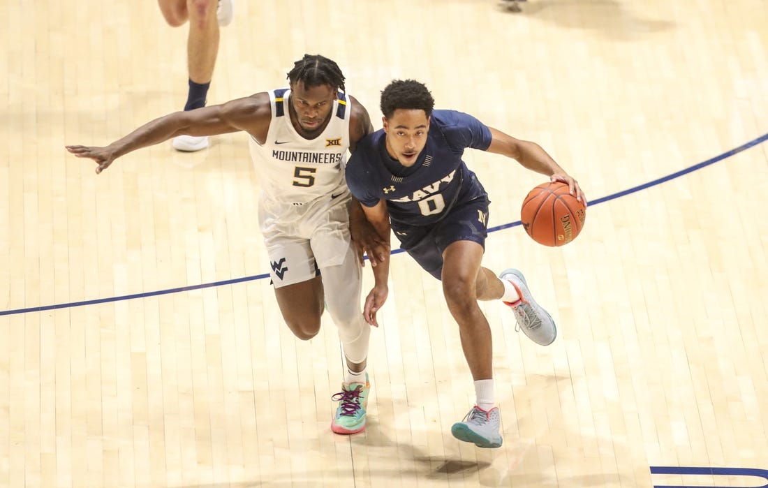 Dec 7, 2022; Morgantown, West Virginia, USA; Navy Midshipmen guard Austin Inge (0) dribbles against West Virginia Mountaineers guard Joe Toussaint (5) during the first half at WVU Coliseum. Mandatory Credit: Ben Queen-USA TODAY Sports