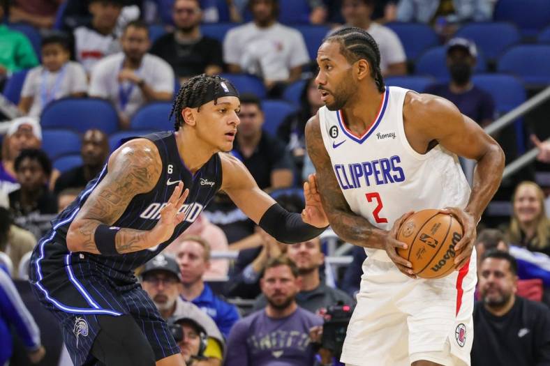Dec 7, 2022; Orlando, Florida, USA; LA Clippers forward Kawhi Leonard (2) looks to pass in front of Orlando Magic forward Paolo Banchero (5) during the first quarter at Amway Center. Mandatory Credit: Mike Watters-USA TODAY Sports