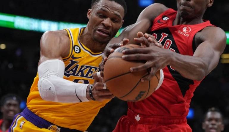 Dec 7, 2022; Toronto, Ontario, CAN; Los Angeles Lakers guard Russell Westbrook (0) battles for the ball with Toronto Raptors forward Christian Koloko (35) during the second quarter at the Scotiabank Arena.  Mandatory Credit: Nick Turchiaro-USA TODAY Sports