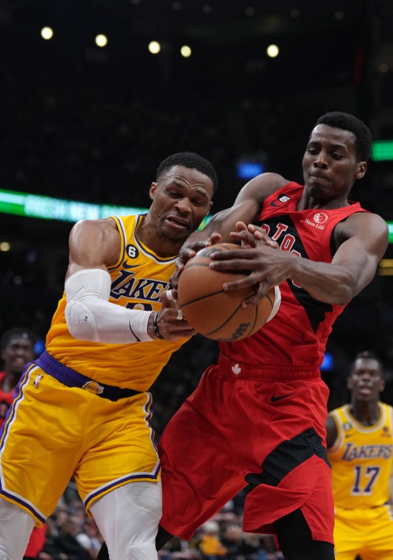 Dec 7, 2022; Toronto, Ontario, CAN; Los Angeles Lakers guard Russell Westbrook (0) battles for the ball with Toronto Raptors forward Christian Koloko (35) during the second quarter at the Scotiabank Arena.  Mandatory Credit: Nick Turchiaro-USA TODAY Sports