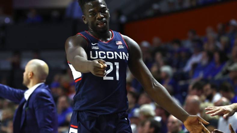 Dec 7, 2022; Gainesville, Florida, USA; Connecticut Huskies forward Adama Sanogo (21) points against the Florida Gators during the second half at Exactech Arena at the Stephen C. O'Connell Center. Mandatory Credit: Kim Klement-USA TODAY Sports