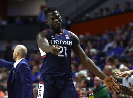 Dec 7, 2022; Gainesville, Florida, USA; Connecticut Huskies forward Adama Sanogo (21) points against the Florida Gators during the second half at Exactech Arena at the Stephen C. O'Connell Center. Mandatory Credit: Kim Klement-USA TODAY Sports