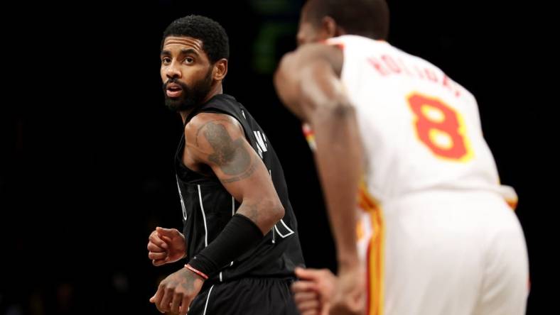 Dec 9, 2022; Brooklyn, New York, USA; Brooklyn Nets guard Kyrie Irving (11) looks back after a basket against Atlanta Hawks forward Justin Holiday (8) during the fourth quarter at Barclays Center. Mandatory Credit: Brad Penner-USA TODAY Sports