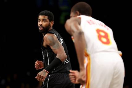 Dec 9, 2022; Brooklyn, New York, USA; Brooklyn Nets guard Kyrie Irving (11) looks back after a basket against Atlanta Hawks forward Justin Holiday (8) during the fourth quarter at Barclays Center. Mandatory Credit: Brad Penner-USA TODAY Sports