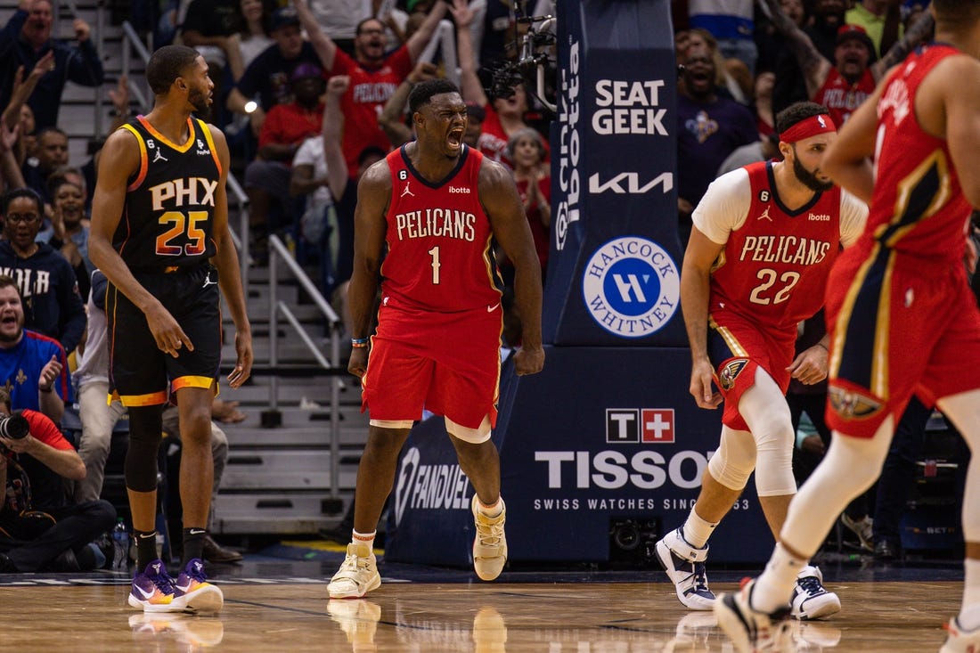 Dec 9, 2022; New Orleans, Louisiana, USA; New Orleans Pelicans forward Zion Williamson (1) reacts to dunking the ball against Phoenix Suns guard Devin Booker (1) and forward Torrey Craig (0) during the second half at Smoothie King Center. Mandatory Credit: Stephen Lew-USA TODAY Sports