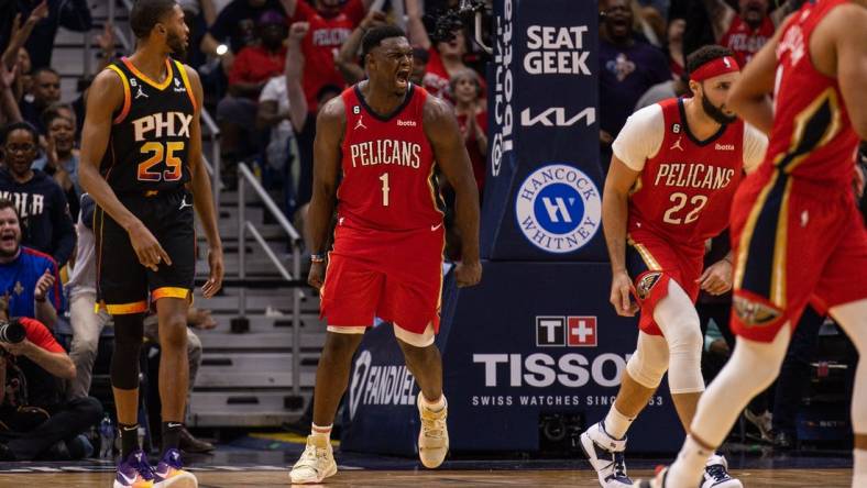 Dec 9, 2022; New Orleans, Louisiana, USA; New Orleans Pelicans forward Zion Williamson (1) reacts to dunking the ball against Phoenix Suns guard Devin Booker (1) and forward Torrey Craig (0) during the second half at Smoothie King Center. Mandatory Credit: Stephen Lew-USA TODAY Sports