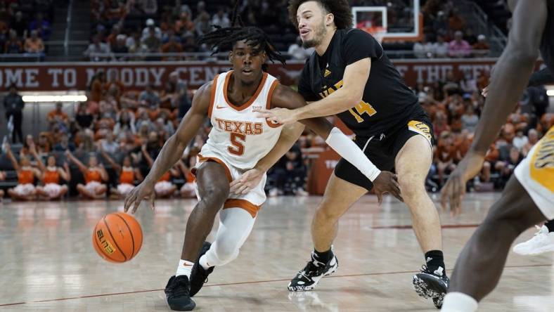 Dec 10, 2022; Austin, Texas, USA; Texas Longhorns guard Marcus Carr (5) drives to the basket Arkansas Pine-Bluff Golden Lions guard Brahm Harris (14) during the first half at Moody Center. Mandatory Credit: Scott Wachter-USA TODAY Sports