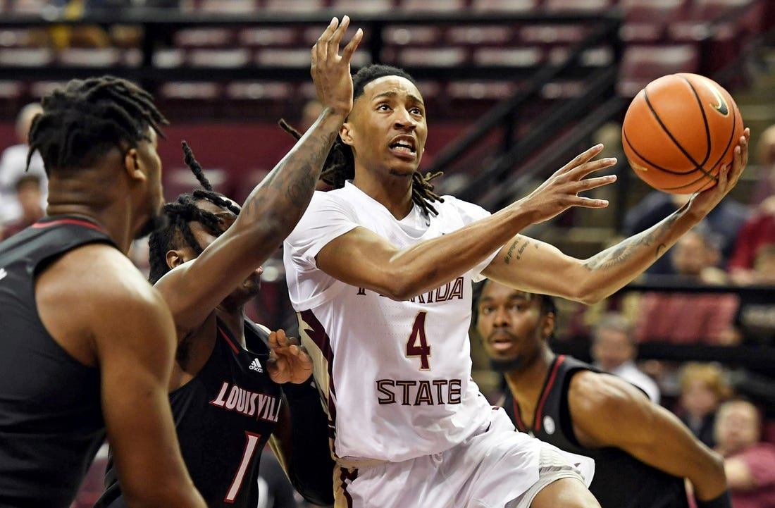 Dec 10, 2022; Tallahassee, Florida, USA; Florida State Seminoles guard Caleb Mills (4) shoots the ball past Louisville Cardinals guard Mike James (1) during the first half at Donald L. Tucker Center. Mandatory Credit: Melina Myers-USA TODAY Sports