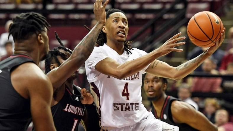 Dec 10, 2022; Tallahassee, Florida, USA; Florida State Seminoles guard Caleb Mills (4) shoots the ball past Louisville Cardinals guard Mike James (1) during the first half at Donald L. Tucker Center. Mandatory Credit: Melina Myers-USA TODAY Sports