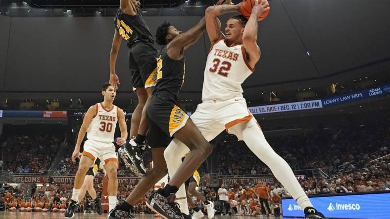 Dec 10, 2022; Austin, Texas, USA; Texas Longhorns forward Christian Bishop (32) drives to the basket against Arkansas Pine-Bluff Golden Lions forward Robert Lewis	(22) and guard AC Curry (24) during the first half at Moody Center. Mandatory Credit: Scott Wachter-USA TODAY Sports