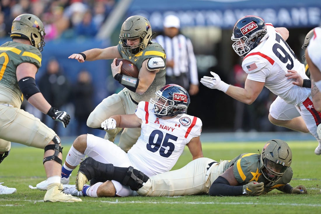 Dec 10, 2022; Philadelphia, Pennsylvania, USA; Army Black Knights quarterback Cade Ballard (18) carries the ball over Navy Midshipmen lineman Jacob Busic (95) during the first half of the 123rd Army-Navy game at Lincoln Financial Field. Mandatory Credit: Danny Wild-USA Today Sports