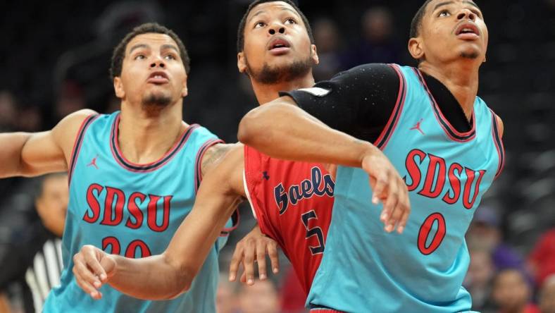 Dec 10, 2022; Phoenix, Arizona, USA; San Diego State Aztecs guard Matt Bradley (20) and San Diego State Aztecs forward Keshad Johnson (0) box out St. Mary's Gaels forward Josh Jefferson (5) during the first half at Footprint Center. Mandatory Credit: Joe Camporeale-USA TODAY Sports