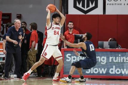 Dec 10, 2022; Queens, New York, USA;  St. John's Red Storm guard Rafael Pinzon (24) looks to pass over New Hampshire Wildcats guard Matt Herasme (13) in the first half at Carnesecca Arena. Mandatory Credit: Wendell Cruz-USA TODAY Sports