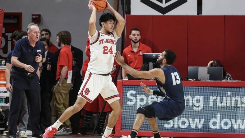 Dec 10, 2022; Queens, New York, USA;  St. John's Red Storm guard Rafael Pinzon (24) looks to pass over New Hampshire Wildcats guard Matt Herasme (13) in the first half at Carnesecca Arena. Mandatory Credit: Wendell Cruz-USA TODAY Sports