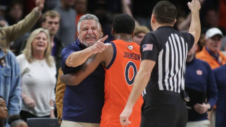 Dec 10, 2022; Atlanta, Georgia, USA; Auburn Tigers head coach Bruce Pearl is held back by guard K.D. Johnson (0) after a technical foul in the second half against the Memphis Tigers at State Farm Arena. Mandatory Credit: Brett Davis-USA TODAY Sports