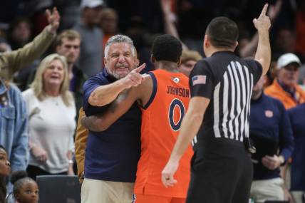 Dec 10, 2022; Atlanta, Georgia, USA; Auburn Tigers head coach Bruce Pearl is held back by guard K.D. Johnson (0) after a technical foul in the second half against the Memphis Tigers at State Farm Arena. Mandatory Credit: Brett Davis-USA TODAY Sports