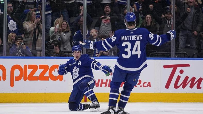 Dec 10, 2022; Toronto, Ontario, CAN; Toronto Maple Leafs forward Mitchell Marner (16) celebrates with forward Auston Matthews (34) after scoring the game winning goal against the Calgary Flames during overtime at Scotiabank Arena. Mandatory Credit: John E. Sokolowski-USA TODAY Sports