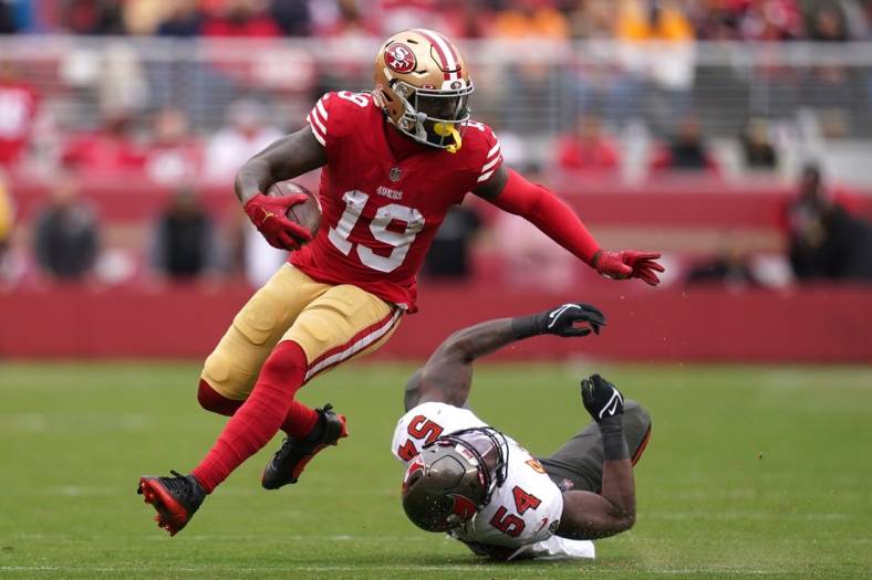 Dec 11, 2022; Santa Clara, California, USA; San Francisco 49ers wide receiver Deebo Samuel (19) runs with the ball in front of Tampa Bay Buccaneers linebacker Lavonte David (54) in the second quarter at Levi's Stadium. Mandatory Credit: Cary Edmondson-USA TODAY Sports
