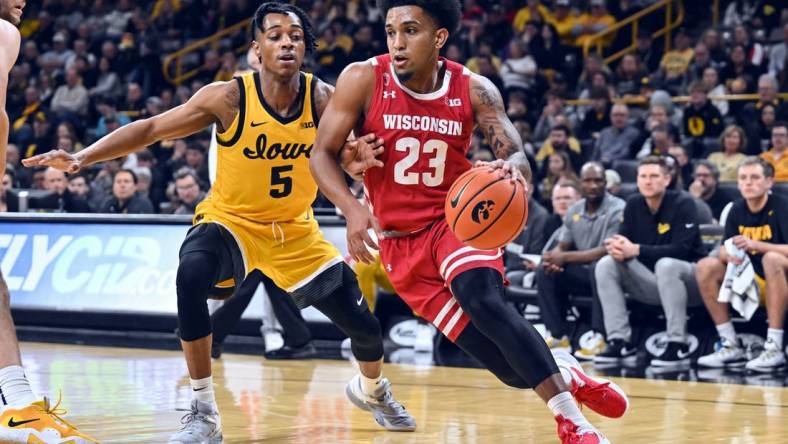 Dec 11, 2022; Iowa City, Iowa, USA; Wisconsin Badgers guard Chucky Hepburn (23) goes to the basket as Iowa Hawkeyes guard Dasonte Bowen (5) defends during the first half at Carver-Hawkeye Arena. Mandatory Credit: Jeffrey Becker-USA TODAY Sports