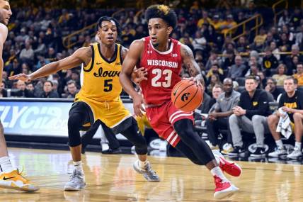 Dec 11, 2022; Iowa City, Iowa, USA; Wisconsin Badgers guard Chucky Hepburn (23) goes to the basket as Iowa Hawkeyes guard Dasonte Bowen (5) defends during the first half at Carver-Hawkeye Arena. Mandatory Credit: Jeffrey Becker-USA TODAY Sports