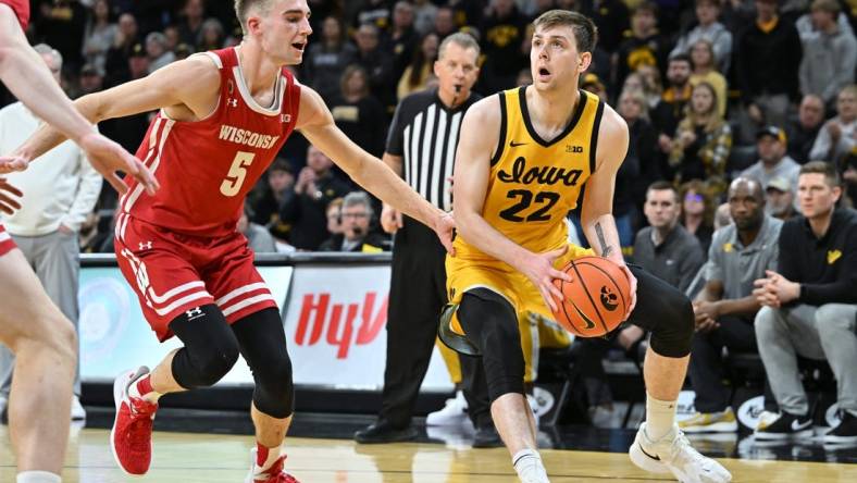 Dec 11, 2022; Iowa City, Iowa, USA; Iowa Hawkeyes forward Patrick McCaffery (22) is defended by Wisconsin Badgers forward Tyler Wahl (5) during overtime at Carver-Hawkeye Arena. Mandatory Credit: Jeffrey Becker-USA TODAY Sports