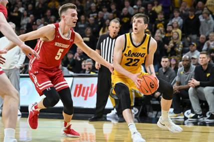 Dec 11, 2022; Iowa City, Iowa, USA; Iowa Hawkeyes forward Patrick McCaffery (22) is defended by Wisconsin Badgers forward Tyler Wahl (5) during overtime at Carver-Hawkeye Arena. Mandatory Credit: Jeffrey Becker-USA TODAY Sports