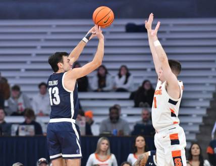 Dec 12, 2022; Syracuse, New York, USA; Monmouth Hawks guard Jack Collins (13) shoots from the corner as Syracuse Orange guard Joseph Girard III (11) defends in the first half at JMA Wireless Dome. Mandatory Credit: Mark Konezny-USA TODAY Sports