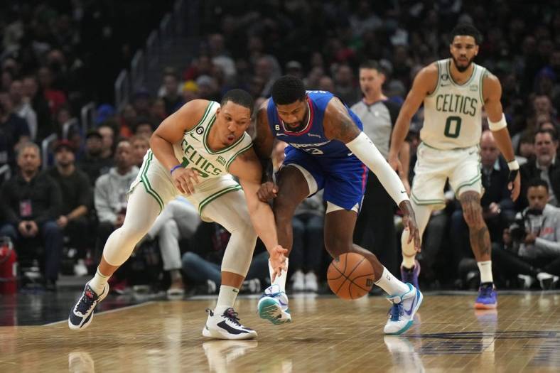 Dec 12, 2022; Los Angeles, California, USA; Boston Celtics guard Malcolm Brogdon (left) and guard Paul George (13) reach for the ball in the first half at Crypto.com Arena. Mandatory Credit: Kirby Lee-USA TODAY Sports