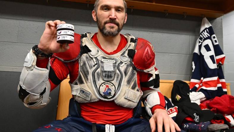 Dec 13, 2022; Chicago, Illinois, USA; Washington Capitals forward Alex Ovechkin (8) poses with the three pucks he scored with against the Chicago Blackhawks to reach the 800 goal career milestone at United Center. Mandatory Credit: Jamie Sabau-USA TODAY Sports