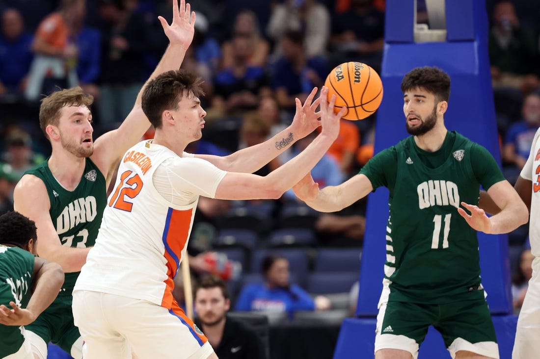 Dec 14, 2022; Tampa, Florida, USA; Florida Gators forward Colin Castleton (12) passes the ball past Ohio Bobcats center Gabe Wiznitzer (11) during the first half at Amalie Arena. Mandatory Credit: Kim Klement-USA TODAY Sports