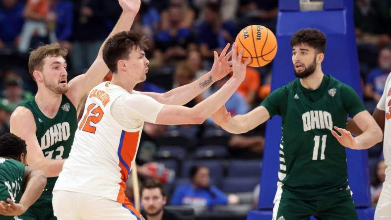 Dec 14, 2022; Tampa, Florida, USA; Florida Gators forward Colin Castleton (12) passes the ball past Ohio Bobcats center Gabe Wiznitzer (11) during the first half at Amalie Arena. Mandatory Credit: Kim Klement-USA TODAY Sports