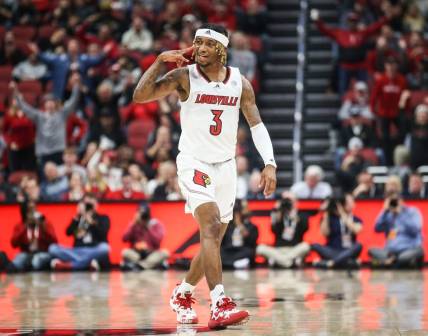Louisville's El Ellis signals a three while he celebrates after hitting a three-point shot early in first half as the Cards beat WKU 94-83 at the Yum! Center in downtown Louisville Wednesday night. Dec. 14, 2022

Louisville Men Vs Western Kentucky Basketball 2022