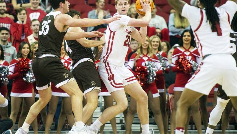 Dec 15, 2022; Madison, Wisconsin, USA;  Wisconsin Badgers forward Steven Crowl (22) looks to pass the ball under coverage by Lehigh Mountain Hawks forward Dominic Parolin (35) and guard Reed Fenton (4) during the first half at the Kohl Center. Mandatory Credit: Kayla Wolf-USA TODAY Sports