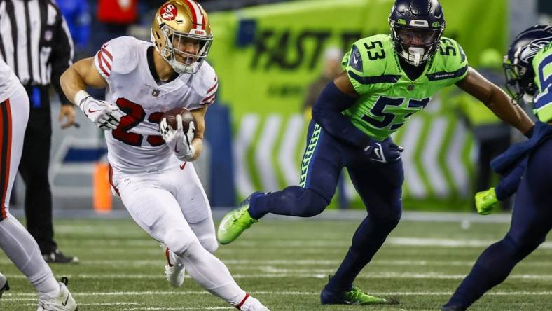 Dec 15, 2022; Seattle, Washington, USA; San Francisco 49ers running back Christian McCaffrey (23) rushes against the Seattle Seahawks during the second quarter at Lumen Field. Seattle Seahawks linebacker Boye Mafe (53) follows the play at right. Mandatory Credit: Joe Nicholson-USA TODAY Sports