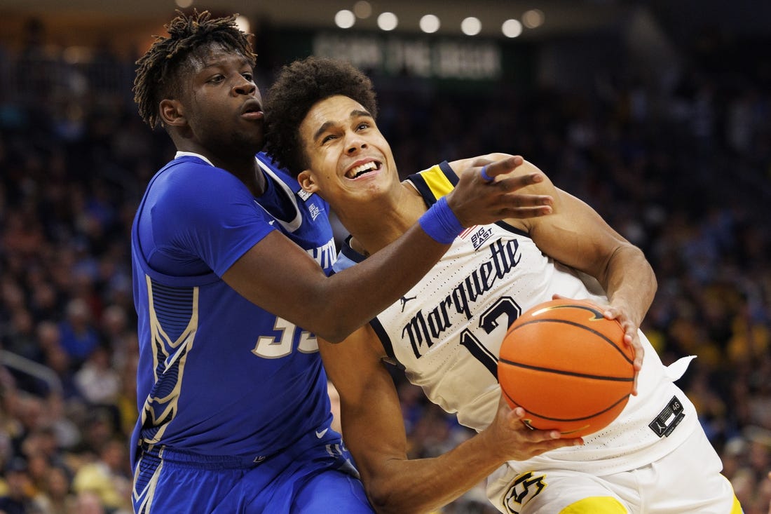 Dec 16, 2022; Milwaukee, Wisconsin, USA;  Marquette Golden Eagles forward Oso Ighodaro (13) looks to shoot against Creighton Bluejays center Fredrick King (33) during the second half at Fiserv Forum. Mandatory Credit: Jeff Hanisch-USA TODAY Sports