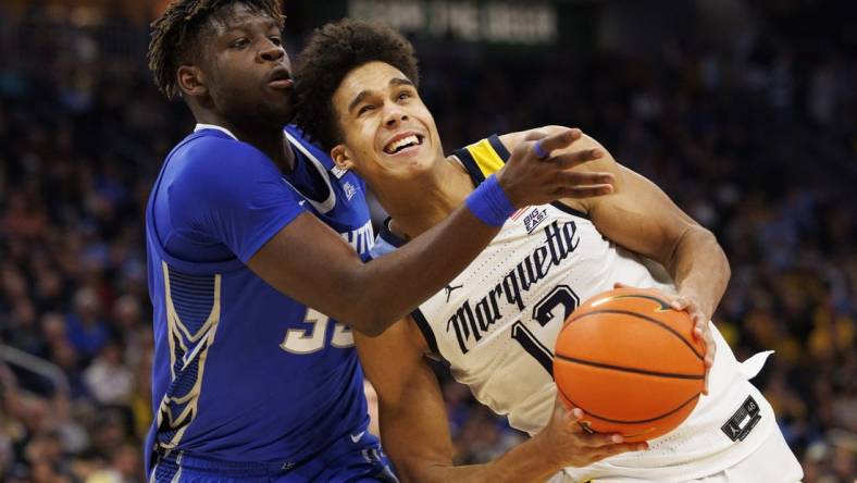 Dec 16, 2022; Milwaukee, Wisconsin, USA;  Marquette Golden Eagles forward Oso Ighodaro (13) looks to shoot against Creighton Bluejays center Fredrick King (33) during the second half at Fiserv Forum. Mandatory Credit: Jeff Hanisch-USA TODAY Sports