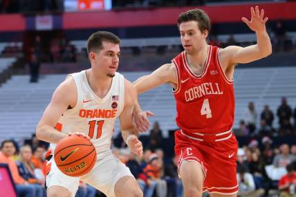 Dec 17, 2022; Syracuse, New York, USA; Syracuse Orange guard Joseph Girard III (11) drives to the basket as Cornell Big Red guard Greg Dolan (4) defends during the first half at the JMA Wireless Dome. Mandatory Credit: Rich Barnes-USA TODAY Sports
