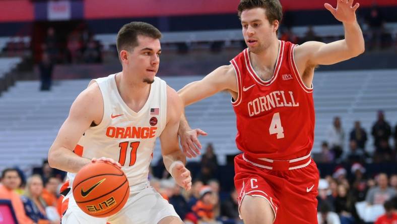 Dec 17, 2022; Syracuse, New York, USA; Syracuse Orange guard Joseph Girard III (11) drives to the basket as Cornell Big Red guard Greg Dolan (4) defends during the first half at the JMA Wireless Dome. Mandatory Credit: Rich Barnes-USA TODAY Sports