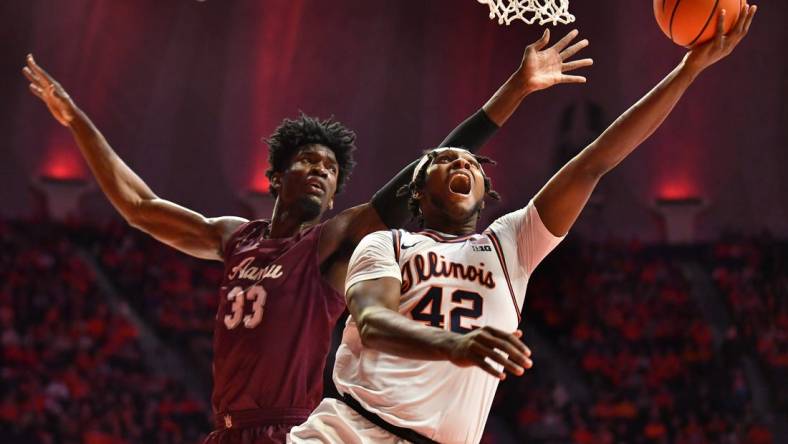 Dec 17, 2022; Champaign, Illinois, USA; Illinois Fighting Illini forward Dain Dainja (42) drives to the basket as Alabama A&M Bulldogs center Olisa Blaise Akonobi (33) defends during the first half at State Farm Center. Mandatory Credit: Ron Johnson-USA TODAY Sports