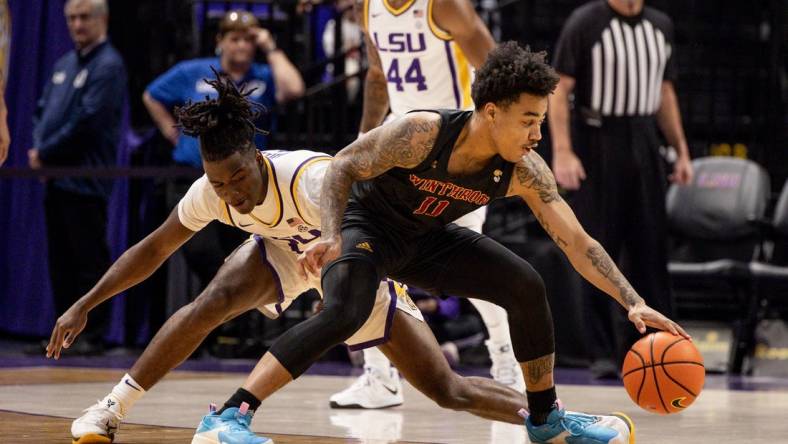 Dec 17, 2022; Baton Rouge, Louisiana, USA;  Winthrop Eagles guard Kasen Harrison (11) dribbles against LSU Tigers guard Cam Hayes (1) during the first half at Pete Maravich Assembly Center. Mandatory Credit: Stephen Lew-USA TODAY Sports