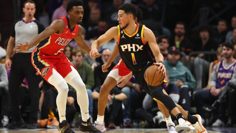 Dec 17, 2022; Phoenix, Arizona, USA; Phoenix Suns guard Devin Booker (1) against New Orleans Pelicans forward Herbert Jones in the first half at Footprint Center. Mandatory Credit: Mark J. Rebilas-USA TODAY Sports