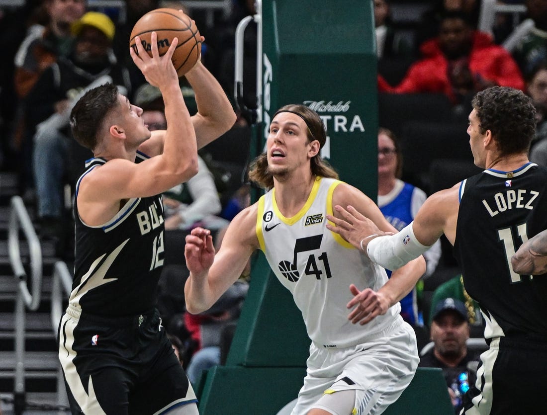 Dec 17, 2022; Milwaukee, Wisconsin, USA; Milwaukee Bucks guard Grayson Allen (12) shoots the ball against Utah Jazz forward Kelly Olynyk (41) in the first quarter at Fiserv Forum. Mandatory Credit: Benny Sieu-USA TODAY Sports