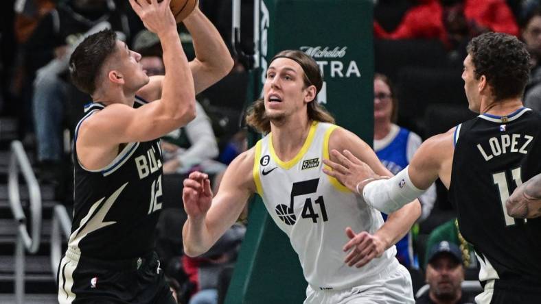 Dec 17, 2022; Milwaukee, Wisconsin, USA; Milwaukee Bucks guard Grayson Allen (12) shoots the ball against Utah Jazz forward Kelly Olynyk (41) in the first quarter at Fiserv Forum. Mandatory Credit: Benny Sieu-USA TODAY Sports