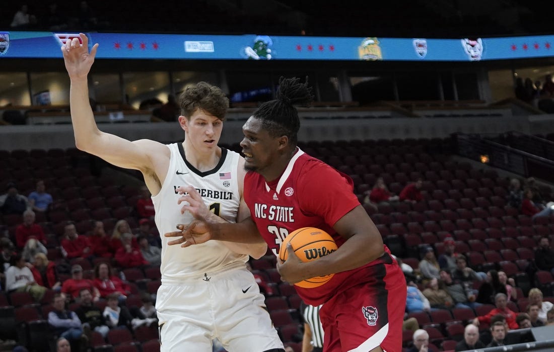 Dec 17, 2022; Chicago, Illinois, USA; Vanderbilt Commodores forward Liam Robbins (21) defends North Carolina State Wolfpack forward D.J. Burns Jr. (30) during the first half  at United Center. Mandatory Credit: David Banks-USA TODAY Sports