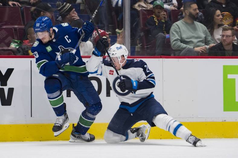 Dec 17, 2022; Vancouver, British Columbia, CAN; Vancouver Canucks forward Bo Horvat (53) collides with Winnipeg Jets forward Karson Kuhlman (20) in the third period at Rogers Arena. Jets won 5-1.Mandatory Credit: Bob Frid-USA TODAY Sports