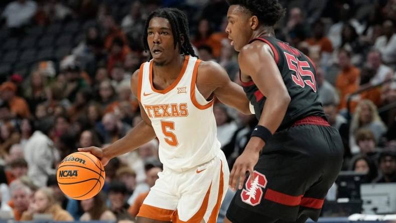 Dec 18, 2022; Dallas, Texas, USA;  Texas Longhorns guard Marcus Carr (5) controls the ball against Stanford Cardinal forward Harrison Ingram (55) during the first half at American Airlines Center. Mandatory Credit: Chris Jones-USA TODAY Sports